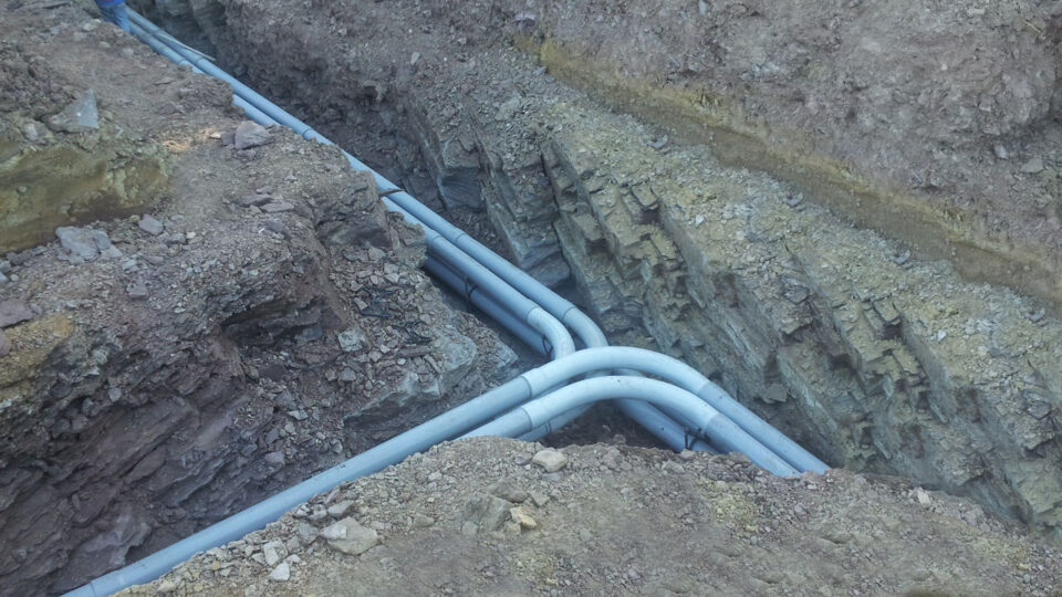 Conduit sweeps in a rock trench ready for utility installation