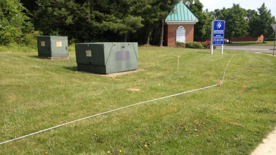 Pad-mounted transformers on a grassy commercial site